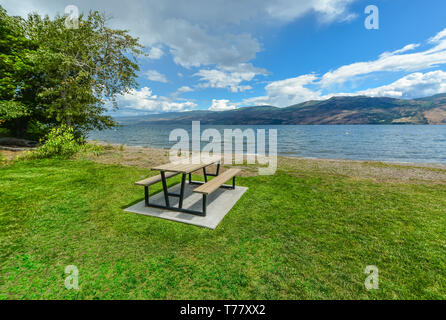 Picknickplatz mit Tisch und Bänken am Ufer des Okanagan See. Stockfoto