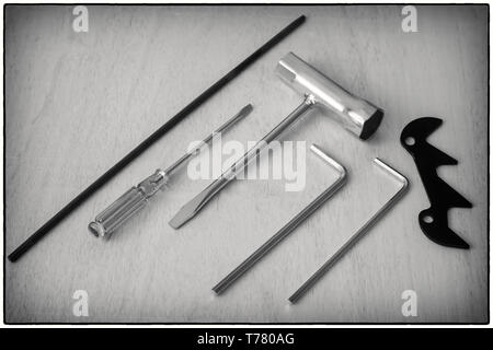 Auf dem hölzernen Tisch sind Schlosser Werkzeuge für die Arbeit. Schwarz-weiß-Bild. Stockfoto