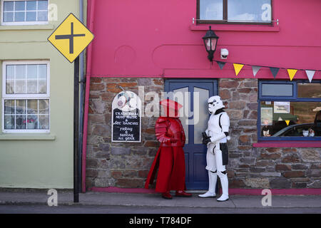 Mitglieder der "501st Legion Irland Garnison' gekleidet als Prätorianergarde (links) und ein Stormtrooper auf den Straßen von Portmagee, Kerry, während der Mai der 4. Festival, wo Szenen aus Star Wars gedreht wurden. Stockfoto