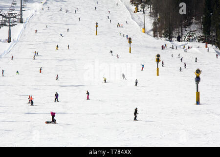 Viele Skifahrer und Snowboarder auf der Piste im Skigebiet Stockfoto