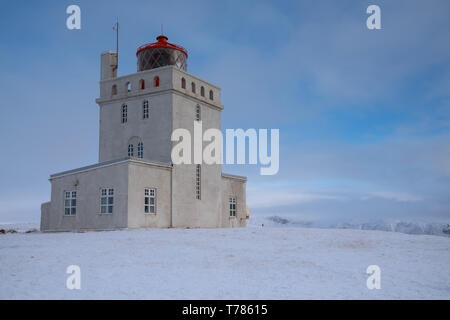 Panoramabild der Leuchtturm am Kap Dyrholaey mit Schnee und am frühen Morgen Licht, Winter in Island Stockfoto