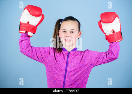 Freude an Sport. Weibliche Boxer. Sport Erziehung. Boxing strenge Disziplin. Mädchen niedliche Boxer auf blauem Hintergrund. Im Gegensatz zu den Stereotypen. Boxer Kind in Boxhandschuhen. Zuversichtlich jugendlich. Stockfoto