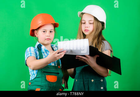 Kleine Mädchen zusammen die Reparatur in der Werkstatt. Schulprojekt. Glückliche Kinder. Kleine Kinder im Helm mit Tablet. Tag der Arbeit. 1. Mai. Meister Inspektor. Reparatur. building Workshop. workshop Arbeitnehmer. Stockfoto