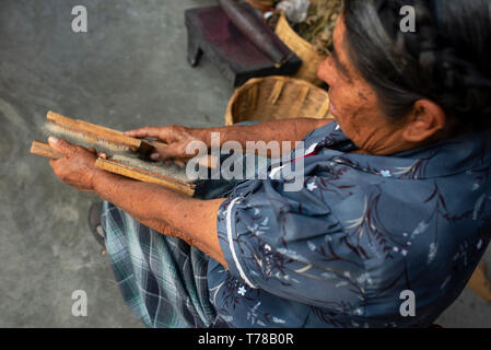 Zapotec Frau kämmen der Rohwolle mit Hand carders vorbereiten wolle Faser für die Spinnerei (Garn). Teotitlan del Valle, Oaxaca, Mexiko. Apr 2019 Stockfoto