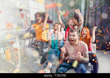 Gerne Freunde der Fußball-Fans, Fußball im Fernsehen und feiern den Sieg mit fallender Konfetti Stockfoto