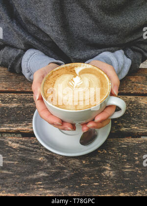 Bild von Tasse Milch Kaffee mit latte Kunst auf Holz- Hintergrund. Schönen Schaum, Keramik Schale, von oben nach unten anzeigen, stilvolle Toning, Platz für Text Stockfoto