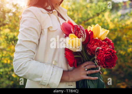 Frau hält einen Strauß Tulpen im Freien. Geschenk zum Muttertag Stockfoto