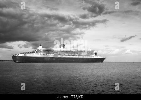 Moody Schwarz-weiß-Foto der Cunard Line Transatlantic Ocean Liner, RMS QUEEN MARY 2, unterwegs vom Hafen von Southampton, Richtung New York Stockfoto