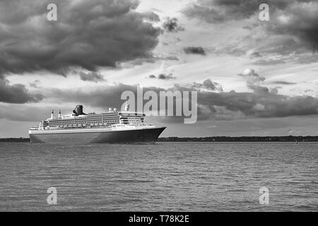 Moody Schwarz-weiß-Foto der Cunard Line Transatlantic Ocean Liner, RMS QUEEN MARY 2, Segel aus dem Hafen von Southampton, nach New York Stockfoto