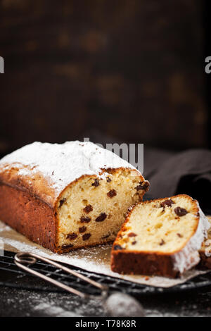 Leckere hausgemachte Quark und Rosinen Brot Kuchen auf dunklen Holzmöbeln im Landhausstil Hintergrund Stockfoto