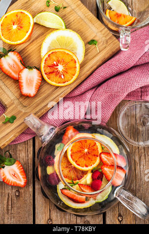 Obst roter Tee Mit Orangen und Beeren auf Holztisch, Ansicht von oben Stockfoto