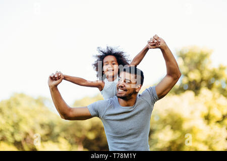 Porträt der jungen Vater, der seine Tochter, die auf dem Rücken Stockfoto