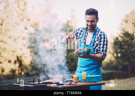 Hübscher junger Mann Vorbereitung Grill in der Natur Stockfoto