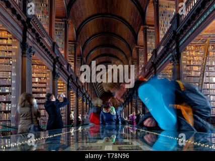 Bewundern Sie alte Bücher in der schönen alten Bibliothek lange Zimmer am Trinity College, Dublin, Irland Stockfoto