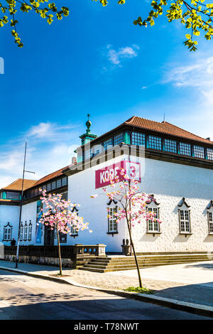 Kode 3 Museum in Bergen, Norwegen im Frühjahr mit Kirschblüte Baum im Vordergrund. Stockfoto