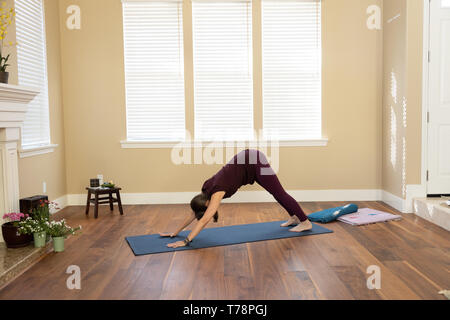 Yoga in den nach unten schauenden Hund darstellen Stockfoto