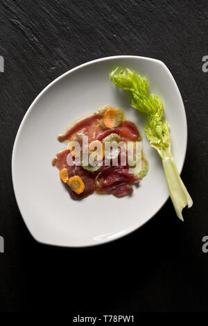 Un Piatto di Carpaccio di carne con guarnizione di Sedano e carote. [ENG] eine Platte von Carpaccio (dünn geschnittenes rohes Fleisch) mit Karotten und ce eingerichtet Stockfoto