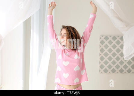 Schöne Frau Eröffnung Vorhänge in Morgen zu Hause Stockfoto