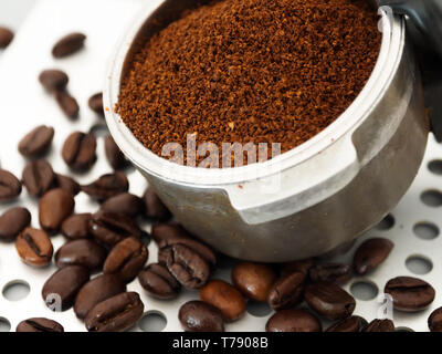 Die duftenden Espresso Kaffeebohnen und gemahlenen Kaffee in den Filterhalter Stockfoto