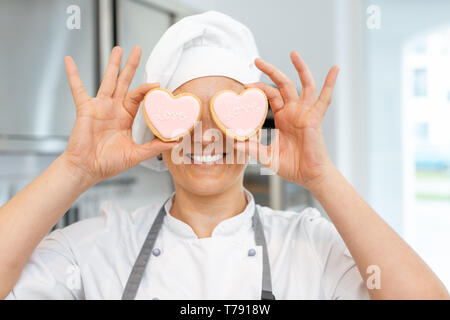 Konditor mit Herzförmigen cookies Stockfoto