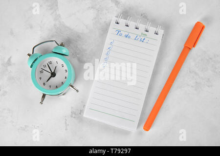 Wecker mit Stift und Zu-Liste auf hellen Hintergrund zu tun. Zeit-management Konzept Stockfoto