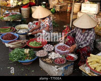 Vietnamesische Frauen verkaufen Zwiebel, Knoblauch und andere Gemüse in Hue Street Market, Vietnam Stockfoto