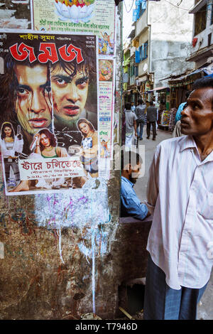 Dhaka, Bangladesch: Ein Mann steht eine Dhallywood (der bengalischen Filmindustrie) Film Poster in Shankhari Basar aka Hindu Straße eine der ältesten Stockfoto
