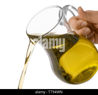 Das Gießen von Olivenöl aus Glas Kanne auf weißem Hintergrund Stockfoto