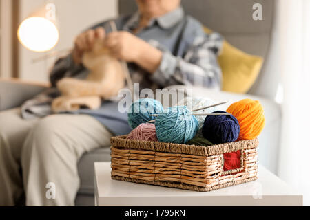 Weidenkorb mit strickgarn auf Tisch Stockfoto