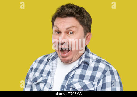 Closeup Portrait von überrascht schön im mittleren Alter business Mann mit Schnurrbart in lässig-kariertem Hemd mit entsetzten Gesicht, in die Kamera zu schauen. Stockfoto