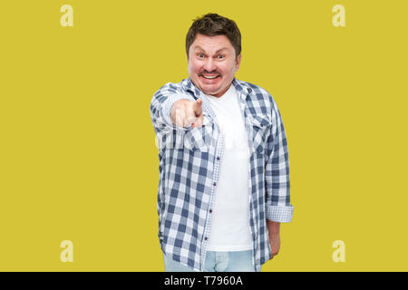 Portrait von Angeregten glücklich aussehenden Mann im mittleren Alter business casual kariertem Hemd stehen, zeigen und auf Kamera mit toothy Lächeln. indo Stockfoto