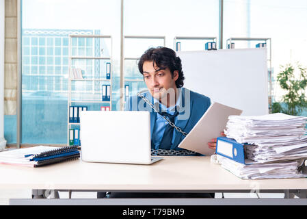 Verkettete männliche Angestellte mit übermäßiger Arbeit unzufrieden Stockfoto