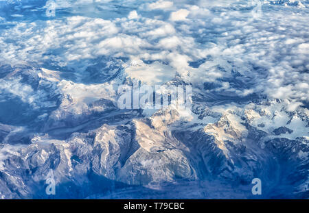 Luftaufnahme von einer dünnen Schicht von Monsun Wolken über die schneebedeckten Gipfel der Dhauladhar/Weiße Palette von Lesser Himalaya in Indien. Stockfoto