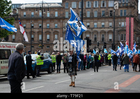 Besonders stolz - auf der Suche Demonstrator hält seine twin Flaggen während der pro-schottische Unabhängigkeit März, organisiert von Alle unter einem Banner (auob). Stockfoto