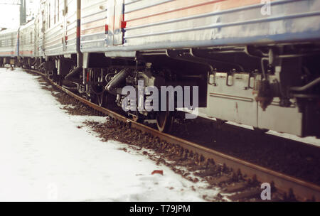 Wagon Train, stehend auf den Schienen, die mit Rost bedeckt sind. Es gibt Schnee rund um die Bahn. Stockfoto