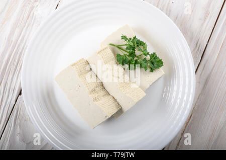 Flach auf Soja Tofu Tofu auf Lehm Gericht Nahaufnahme. Pflanzliche alternative Ersatz für Käse Stockfoto