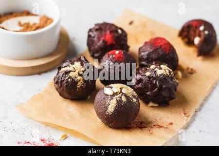 Gesunde raw vegan Energie Kugeln mit Kakao, Termine, Maca, Chia auf weißem Hintergrund. Stockfoto