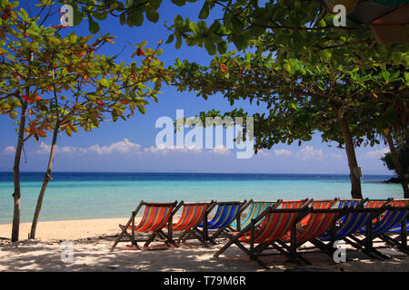 Gruppe von isolierten Leere Liegestühle am Strand von tropischen Insel mit Blick auf türkisblaues Wasser, Ko Phi Phi, Andaman Sea, Thailand Stockfoto