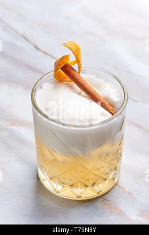 Whisky Sour Alkohol Cocktail mit Eiweiß, orange Zeder und Zimt. Vertikale Stockfoto