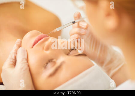 Kosmetologie Arzt macht Schönheit Injektionen in der Lippe zu einer Frau. Stockfoto
