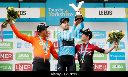 Tour de Yorkshire Sieger Team Ineos' Christopher Lawless (Mitte) feiert mit der Trophäe neben den zweiten Platz das CCC Team Greg Van Avermaet (links) und dritten Platz Team Ineos' Edward Dunbar (rechts) nach Stufe 4 der Tour de Yorkshire. Stockfoto