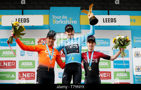 Tour de Yorkshire Sieger Team Ineos' Christopher Lawless (Mitte) feiert mit der Trophäe neben den zweiten Platz das CCC Team Greg Van Avermaet (links) und dritten Platz Team Ineos' Edward Dunbar (rechts) nach Stufe 4 der Tour de Yorkshire. Stockfoto