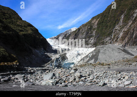 Blick auf den Franz Josef Gletscher, felsigen Aufstieg mit einigen grünen Vegetation auf beiden Seiten, an der Westküste der neuseeländischen Südinsel. Stockfoto