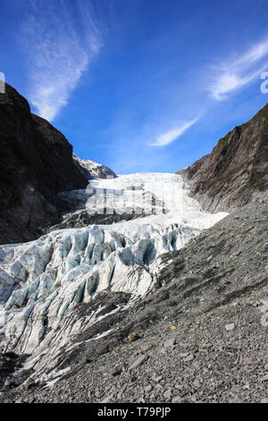 Blick auf den Franz Josef Gletscher, felsigen Aufstieg mit einigen grünen Vegetation auf beiden Seiten, an der Westküste der neuseeländischen Südinsel. Stockfoto