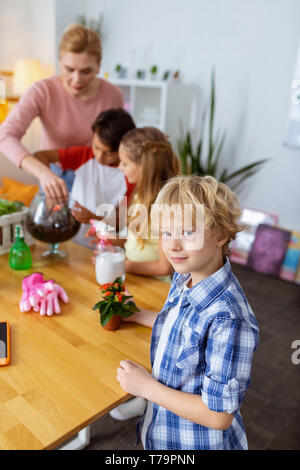 Blonde Schülerin. Blonde Schüler tragen Squared shirt Blumen pflanzen mit Lehrer und Schüler Stockfoto