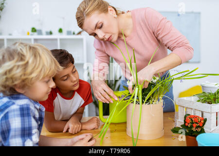 Blick auf Lehrer. Zwei süße Jungs auf Lehrer Gefühl aufmerksam beim Schneiden von trockenen Rändern der Anlage Stockfoto