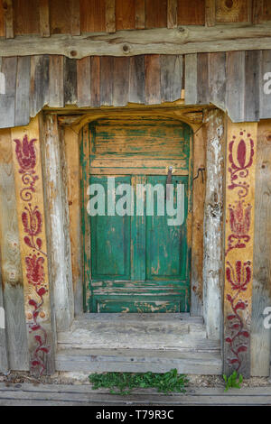 Alte, hölzerne Scheunentor in einem farbenfrohen folkloristischen Stil auf einem Bauernhof in Siebenbürgen, Rumänien Stockfoto