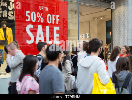 Käufer in der Oxford Street im West End von London vorbei Sommer Verkauf Zeichen in Store Fenster Stockfoto