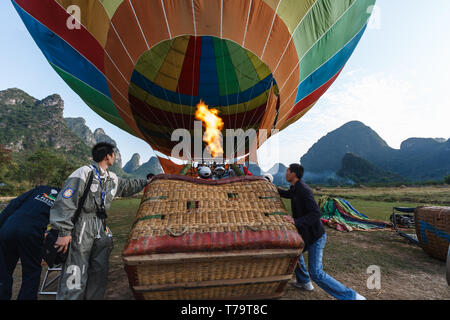 Arbeitnehmer tipp Warenkorb also können Leute in einem Heißluftballon für eine Fahrt über die yangshao Tal und die Berge klettern Stockfoto