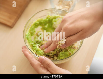 Frau, die nährende Maske mit Avocado in der Küche Stockfoto